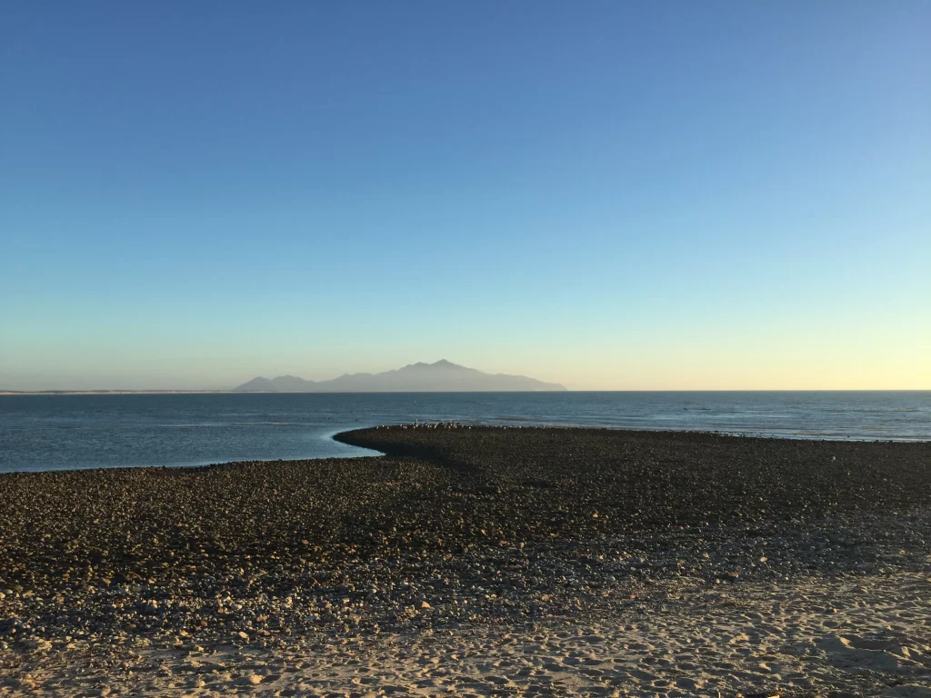 El mar en calma reflejando la luz suave del horizonte al final del día